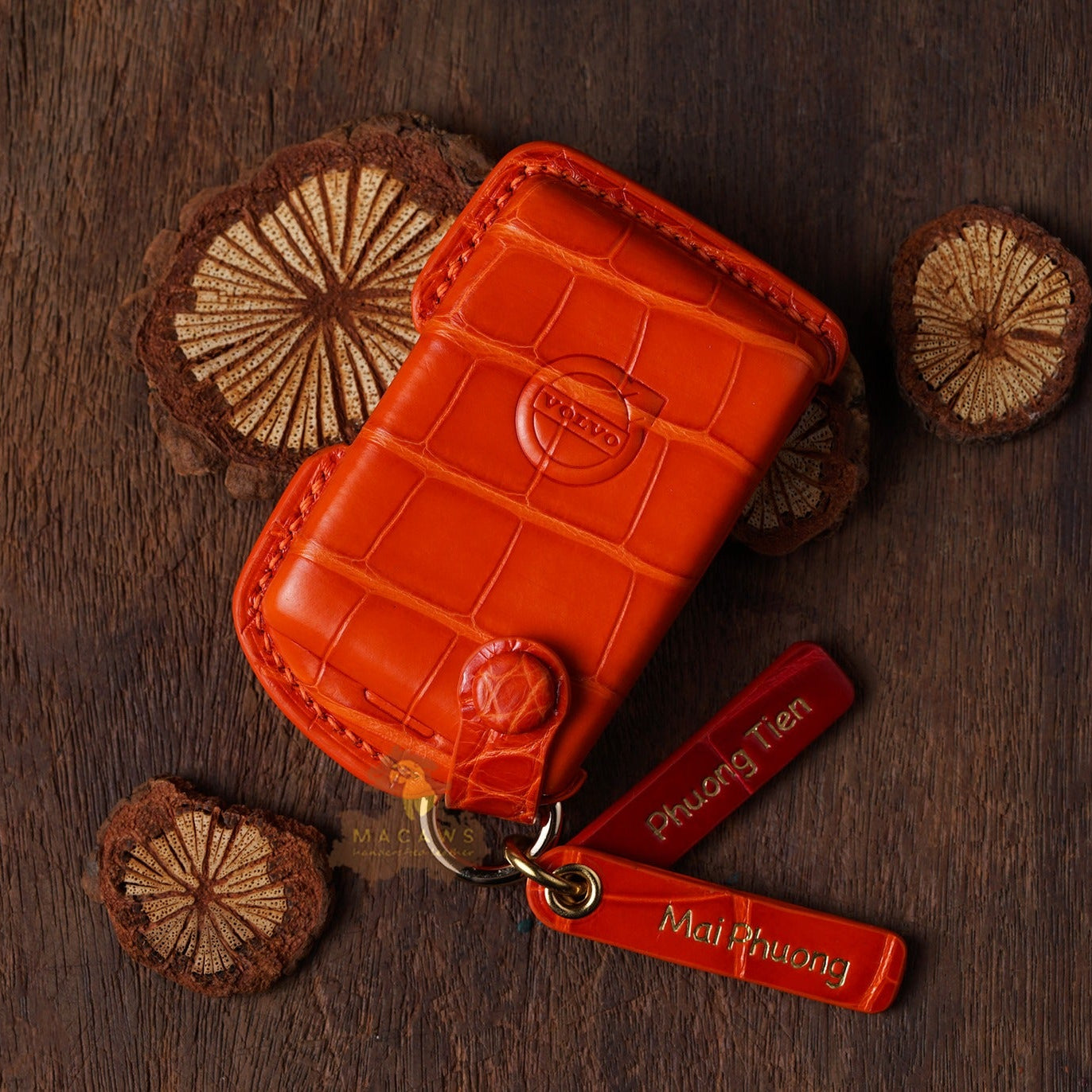 Orange leather wallet with keychain on a wooden surface